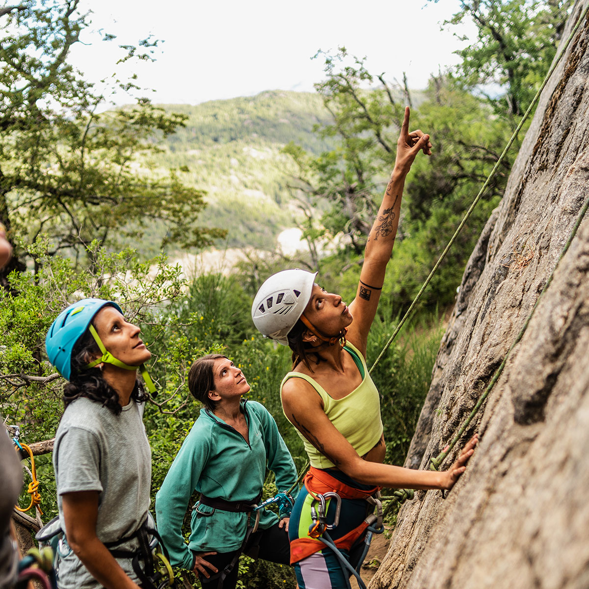 A photo of a group of friends in the woods wearing helmets and preparing to go rock climbing.