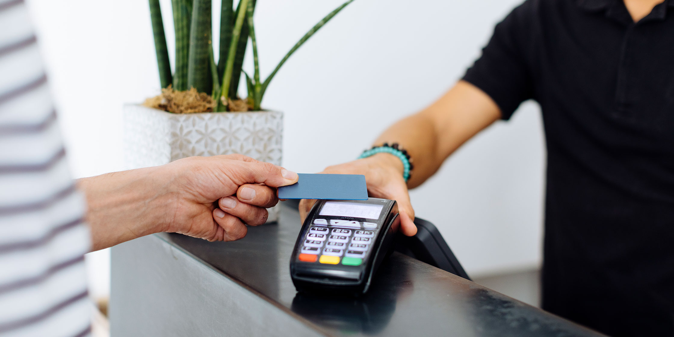A photo of a person using their credit card to make a purchase at a retail store.
