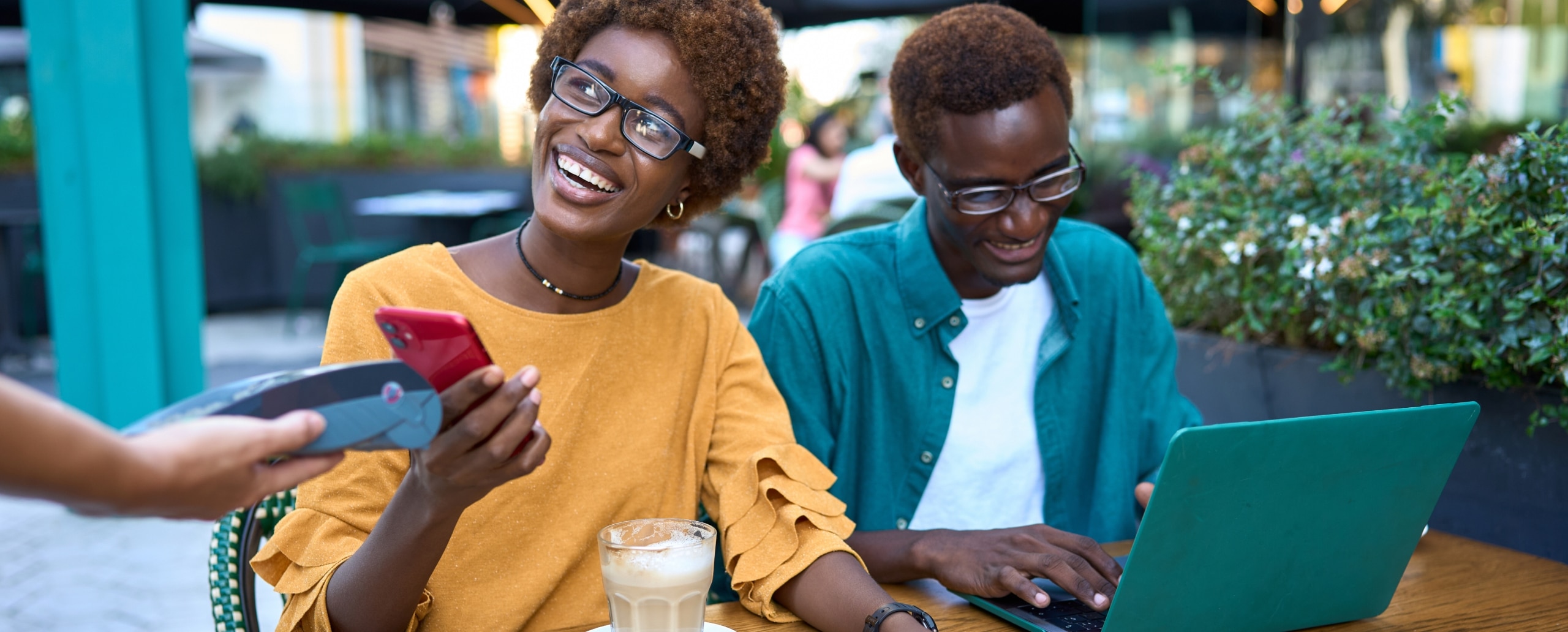 Two people using tap to pay at a cafe.