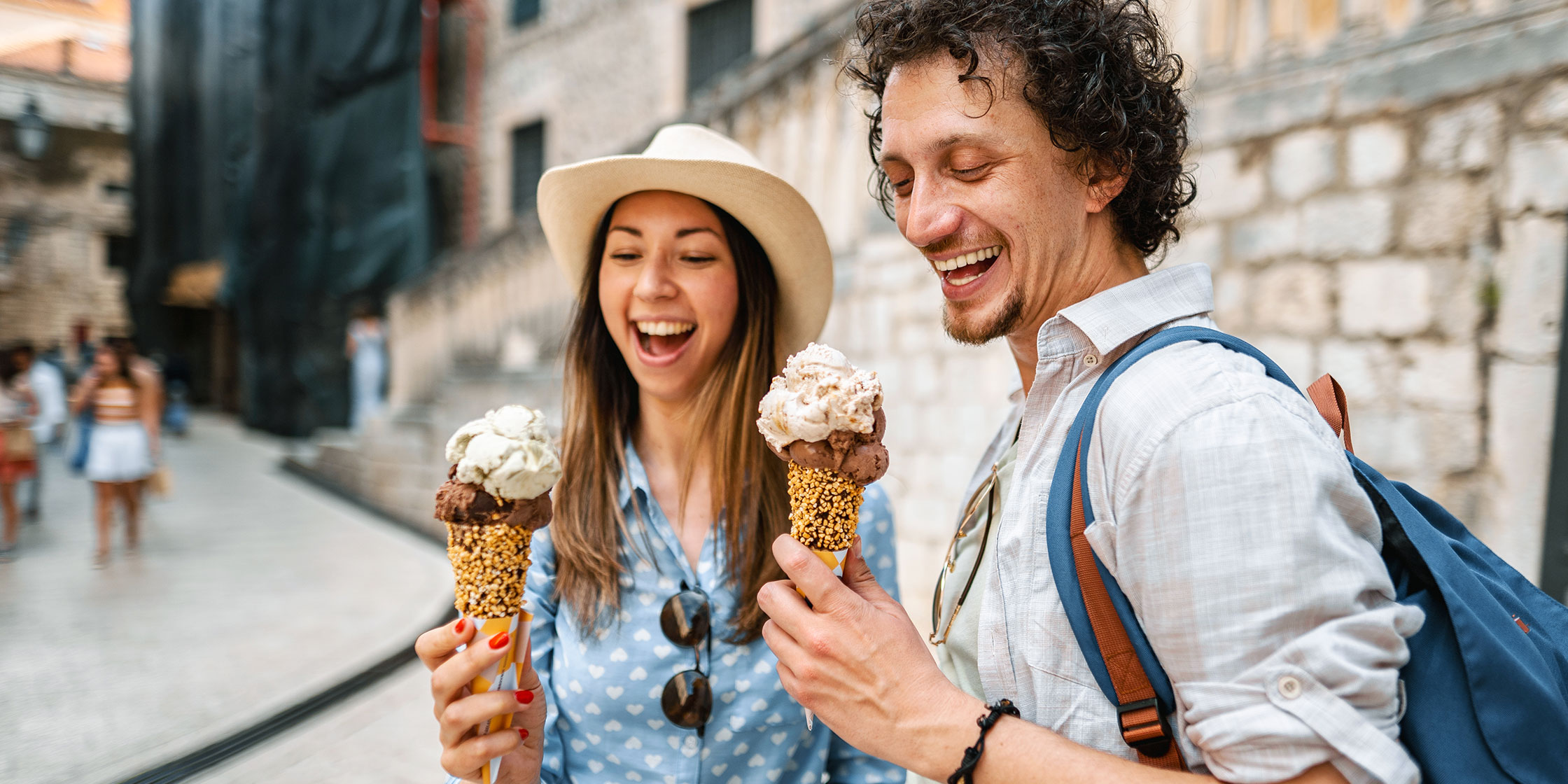 A couple enjoys ice cream cones while traveling abroad.
