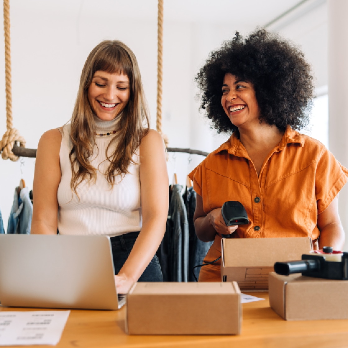 Person at work on laptop and woman scanning boxes